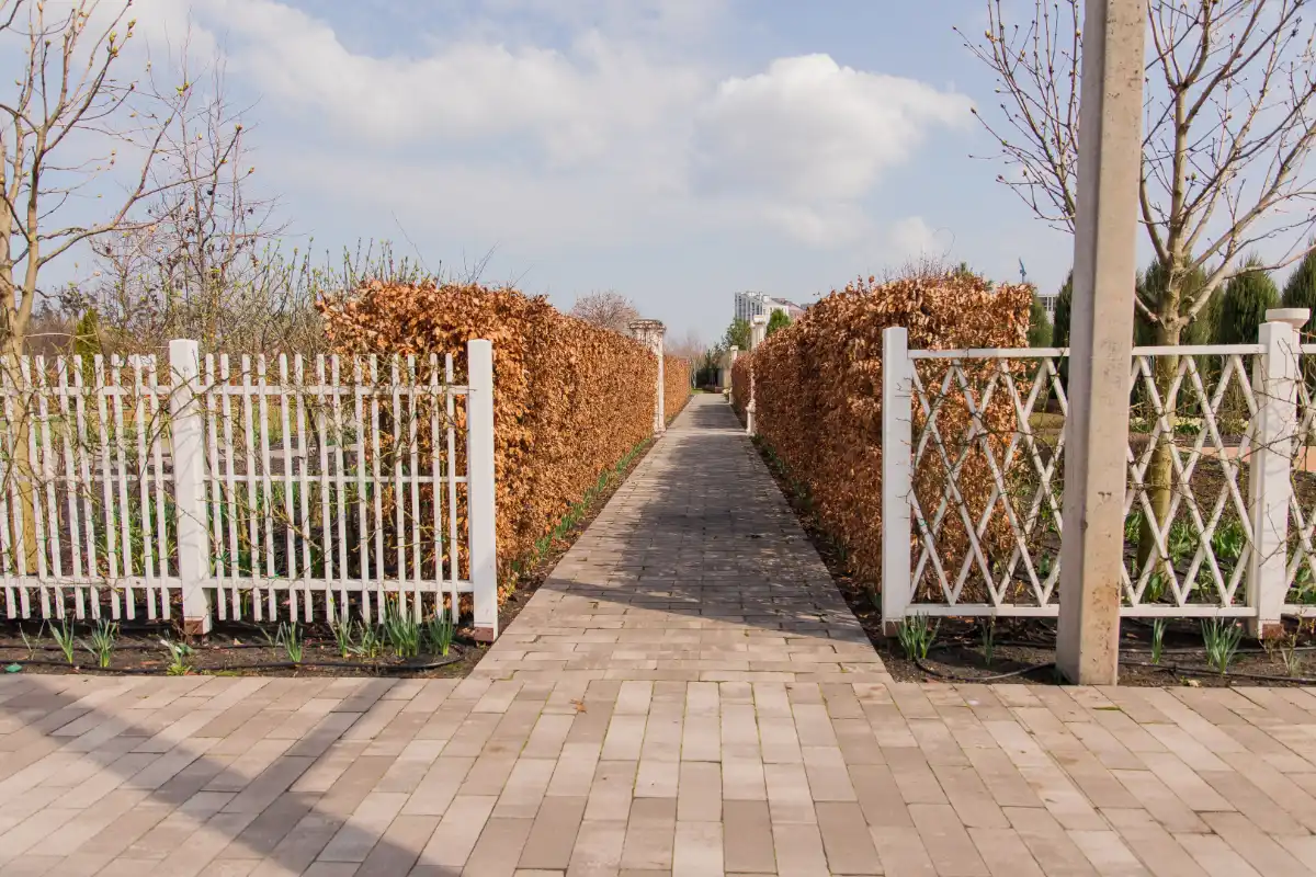 Block paving driveway with decorative fencing and landscaped entrance pathway