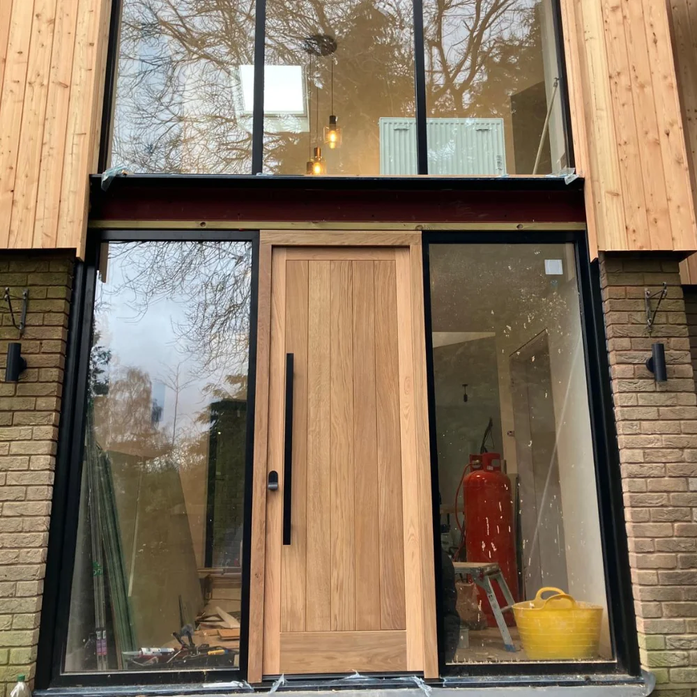 Modern timber front door with large glass panels and black metal framing on a contemporary home2
